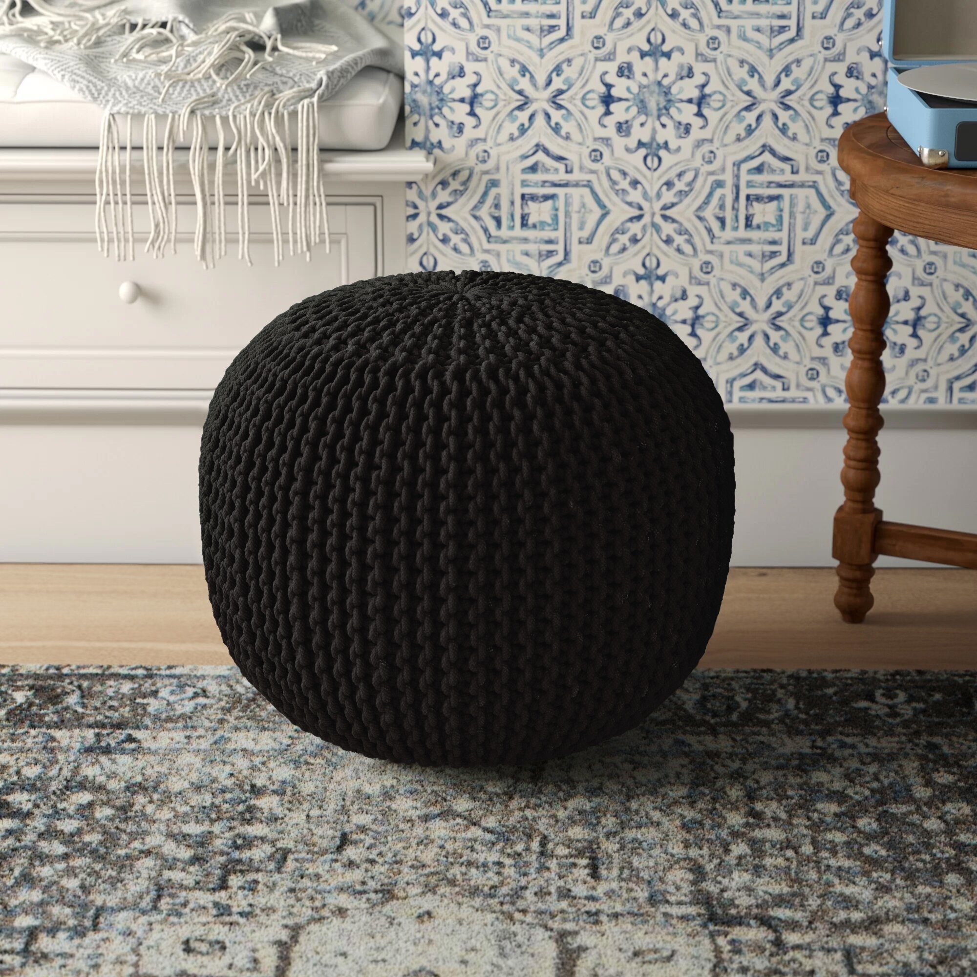 A black ottoman on a rug
