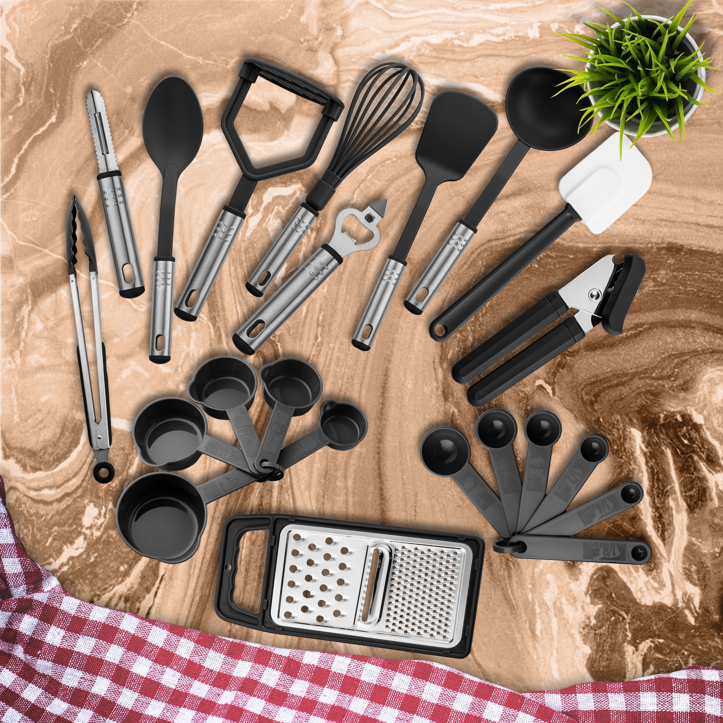 A set of black and silver cooking utensils laid out