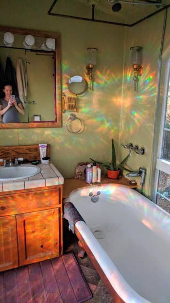reviewer pic of little rainbows bouncing off walls from iridescent privacy film on bathroom window