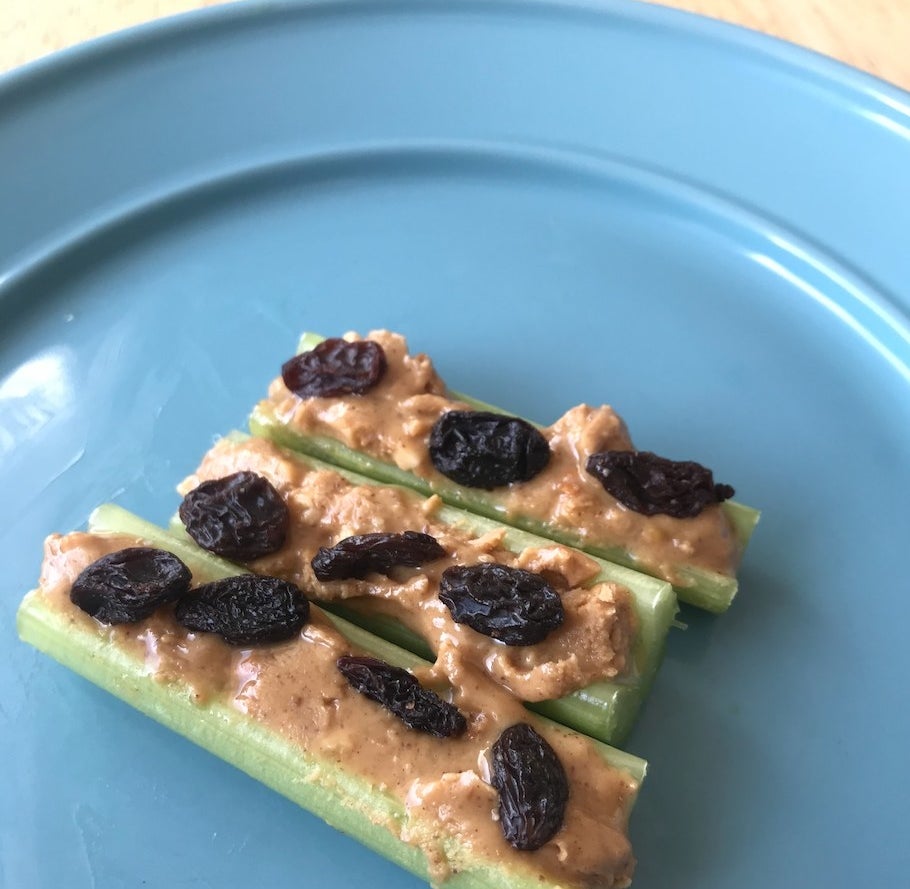 Celery with peanut butter and raisins on a plate