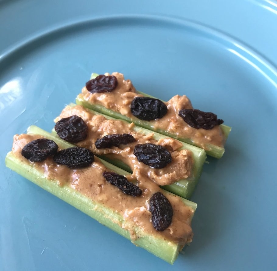 Celery with peanut butter and raisins on a plate
