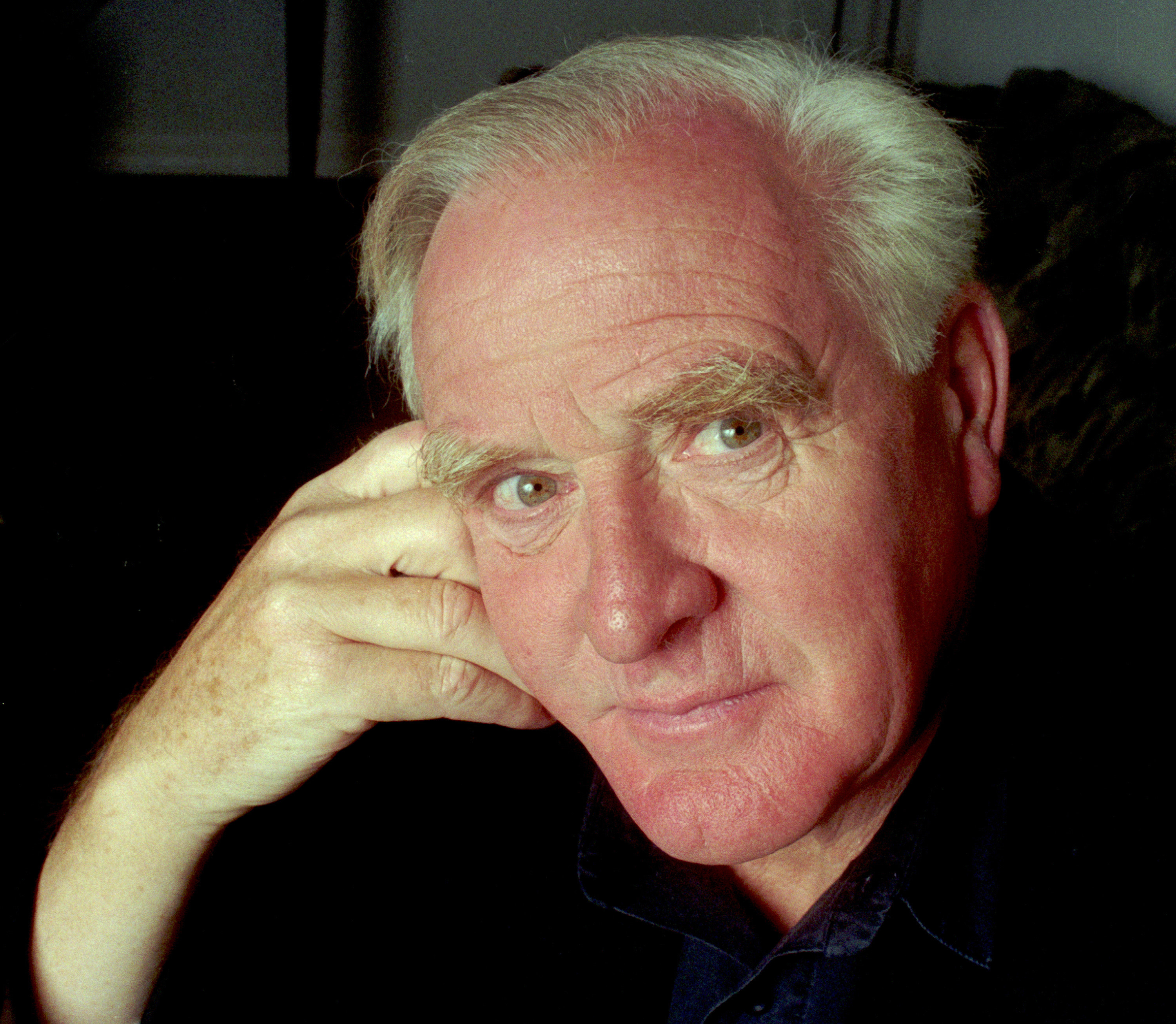 Le Carré, an older man with white hair, posing for the camera