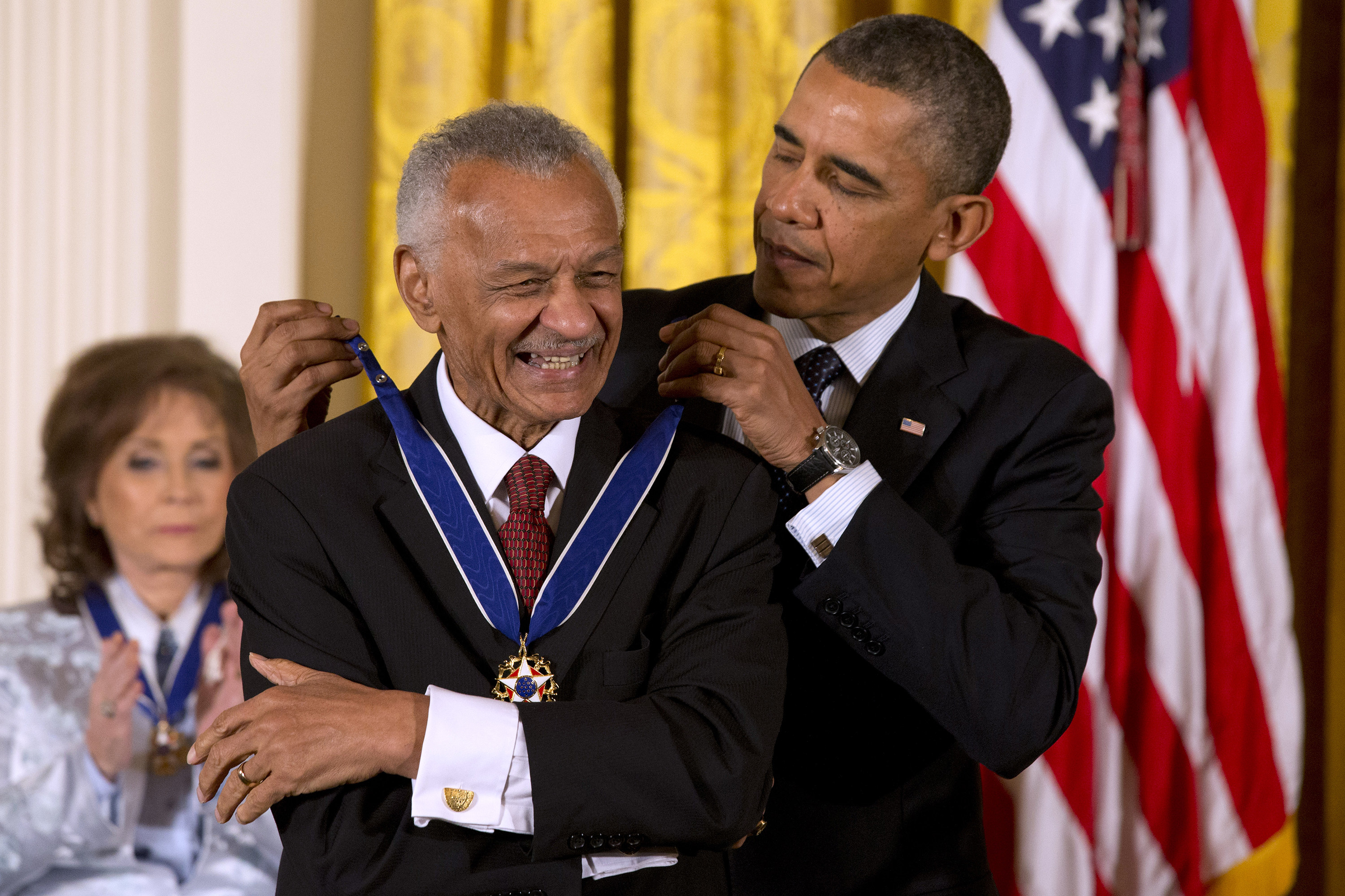 Barack Obama awarding C.T. Vivian an award in front of an American flag