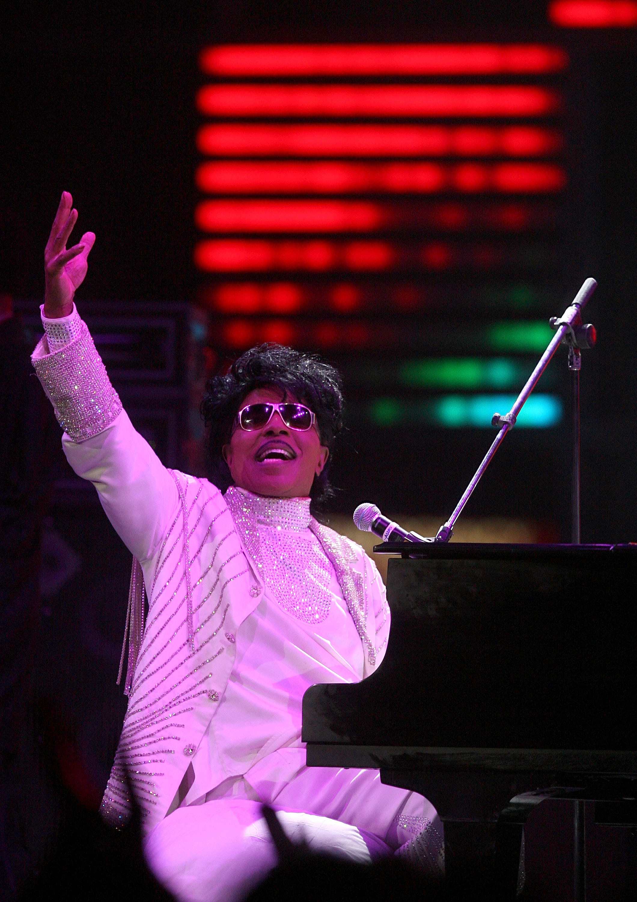 Little Richard on stage performing under pink lights