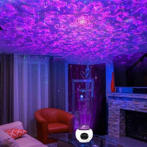 The galaxy light projecting a twinkling pattern onto the ceiling of a living room