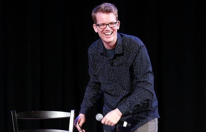 Hank smiles on stage at an event 