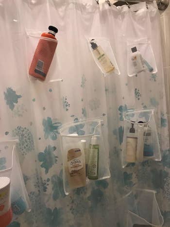 Same transparent shower curtain with bottles of shampoo and conditioner in pockets
