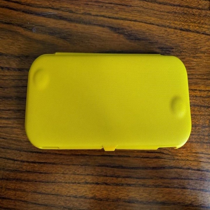 Yellow flip-cover case on Nintendo Switch Lite in closed position