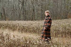 Taylor Swift walking through a field of wheat.