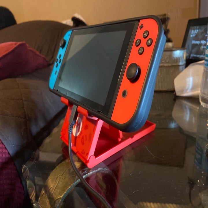 Reviewer photo of Nintendo Switch placed on stand with Mario pattern