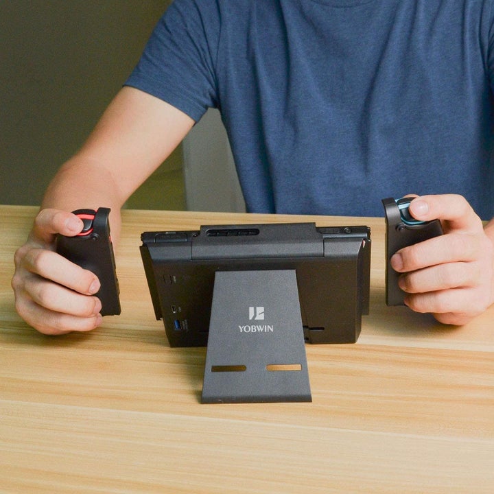 Model playing Nintendo Switch placed in charging case
