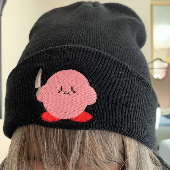 black beanie with patch of kirby holding a knife 