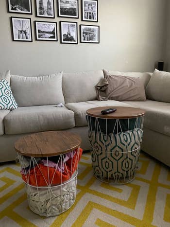 a different reviewer image of two Lavish Home Nesting End Tables with Storage in a customer's living room being used to store blankets and pillows