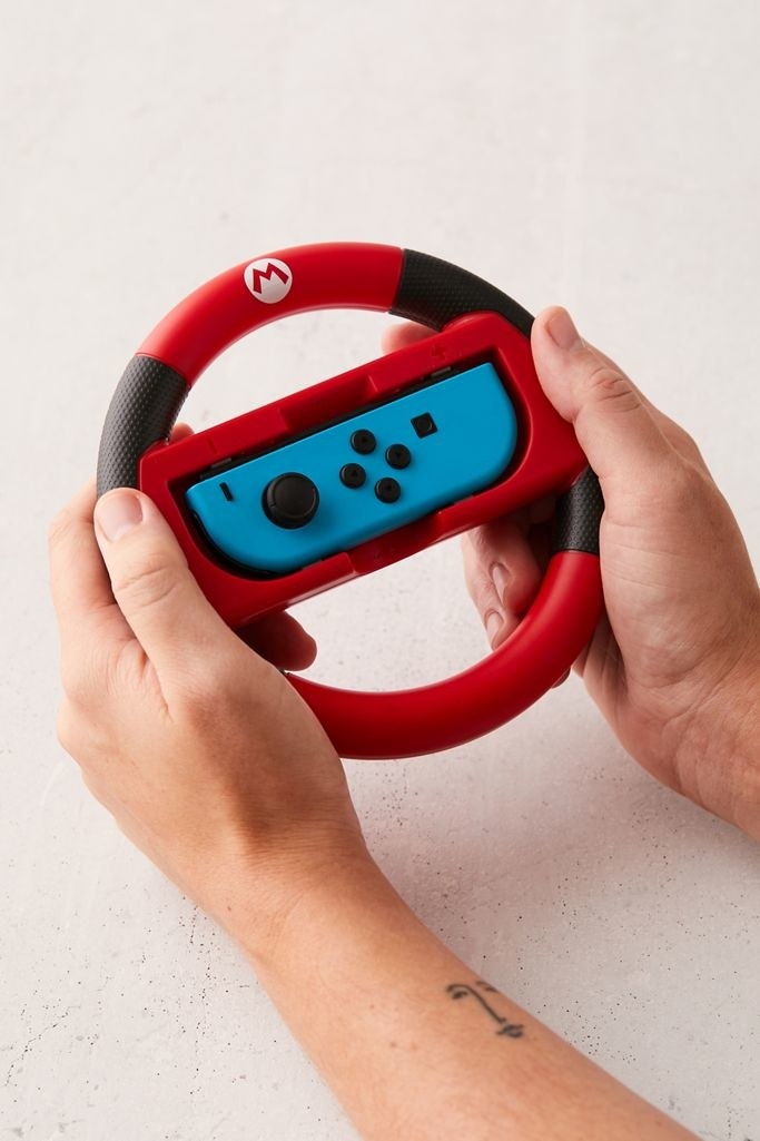 Model holding wheel-shaped attachment with joy-con inside