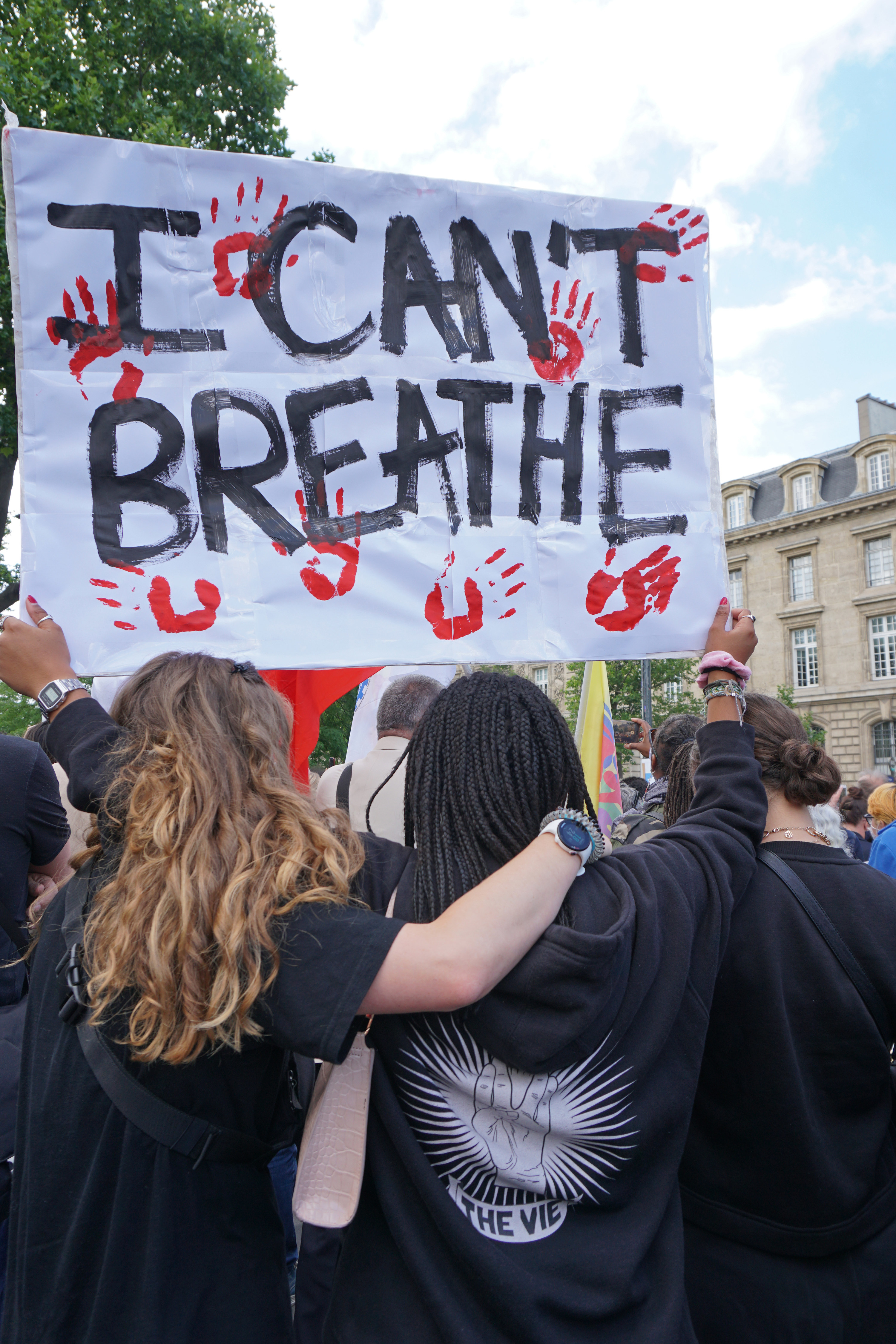 抗议者手持海报,上面写着& # x27;我停下来# x27; t呼吸# x27;都用小手印