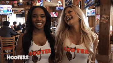 Two Hooters waitresses laughing and then looking very serious.
