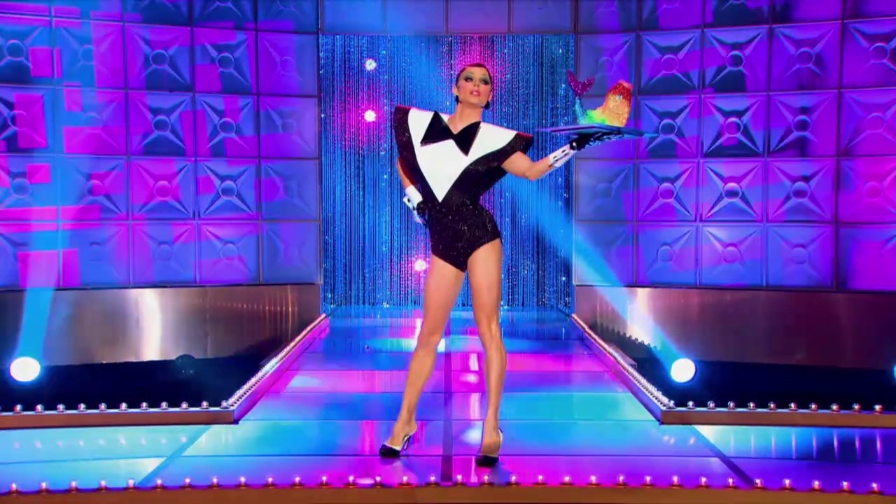 Drag queen Courtney Act wearing an exaggerated tuxedo style leotard