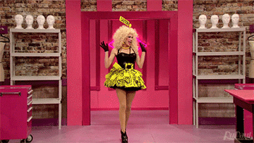 Drag queen Ivy Winters wearing a black mini dress with the skirt, belt buckle, and headpiece made from caution tape