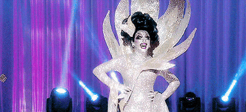 Drag queen Bianca Del Rio wearing a gown with an enormous collar and covered head to toe in silver glitter
