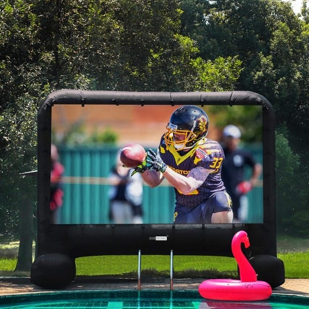 The screen, outdoors with a football game on the screen