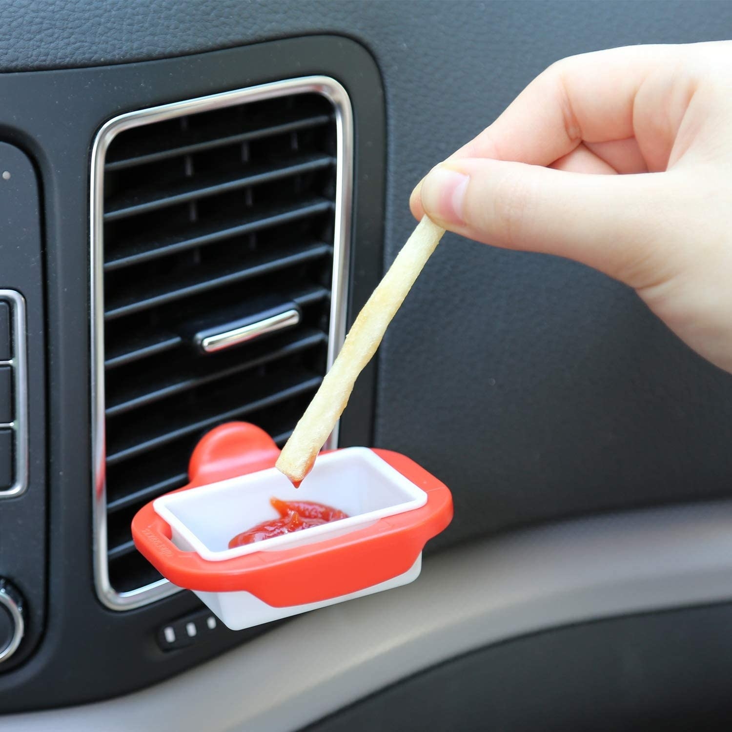 person dipping a dry into a dip clip with ketchup