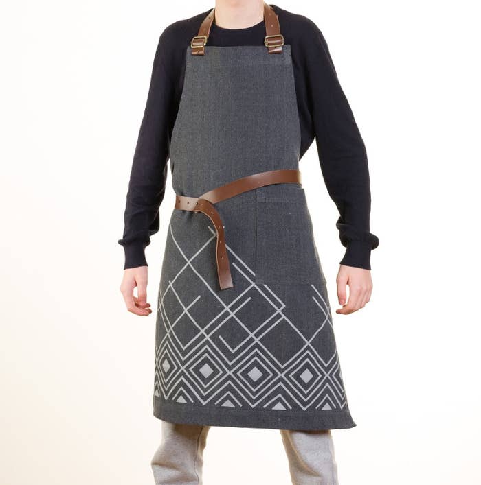 man wearing the apron that is grey and has leather straps