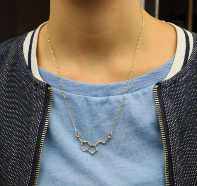 A person wearing the serotonin molecule necklace over a tee shirt