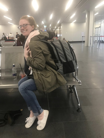 Reviewer wearing gray backpack full of items 