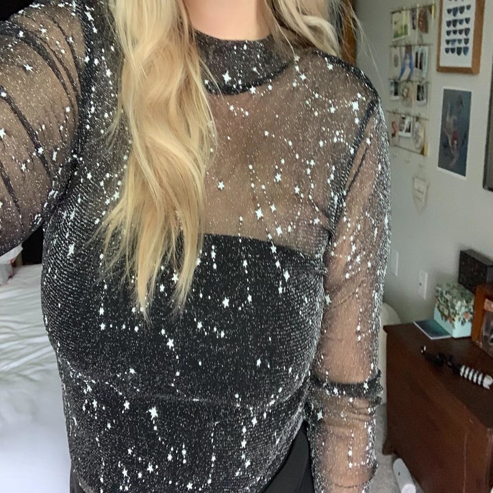 close up of reviewer wearing mesh top with glittery pattern