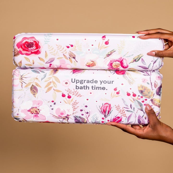 A person's hand holding a small bath pillow