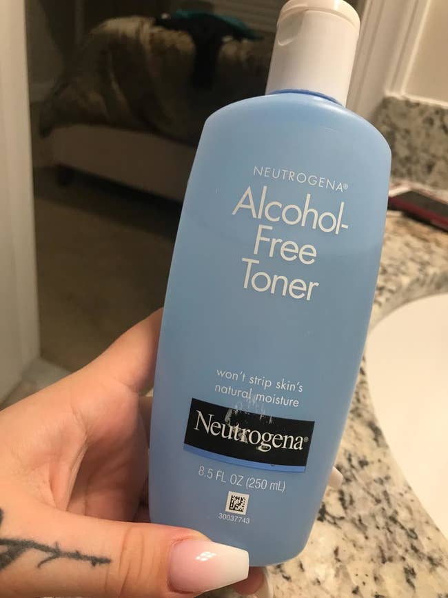 A reviewer holding the 8.5-ounce bottle of toner