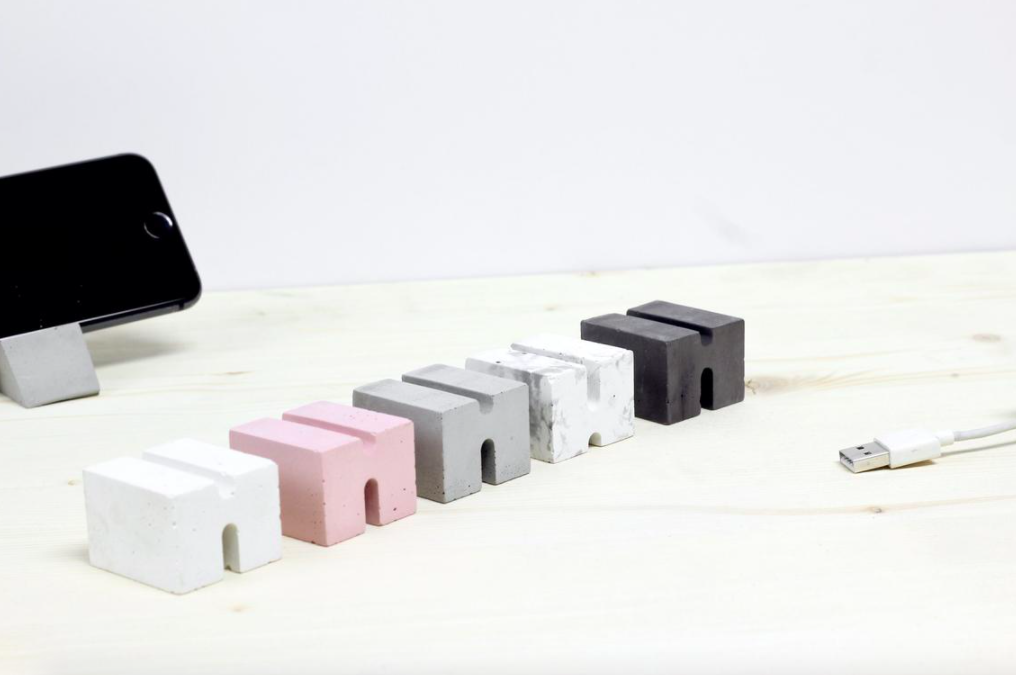 Five cement cable organizers on a desk