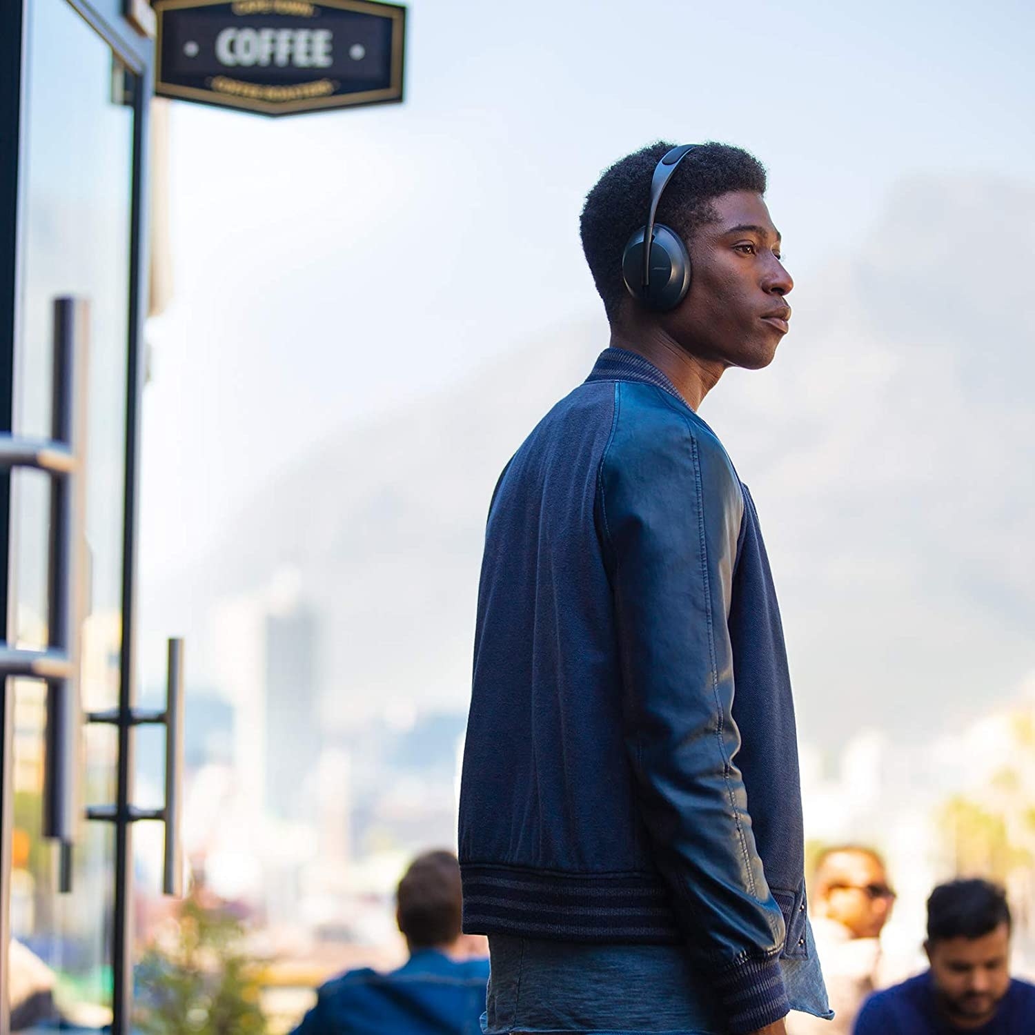 A stylish person wearing the headphones while walking on the street