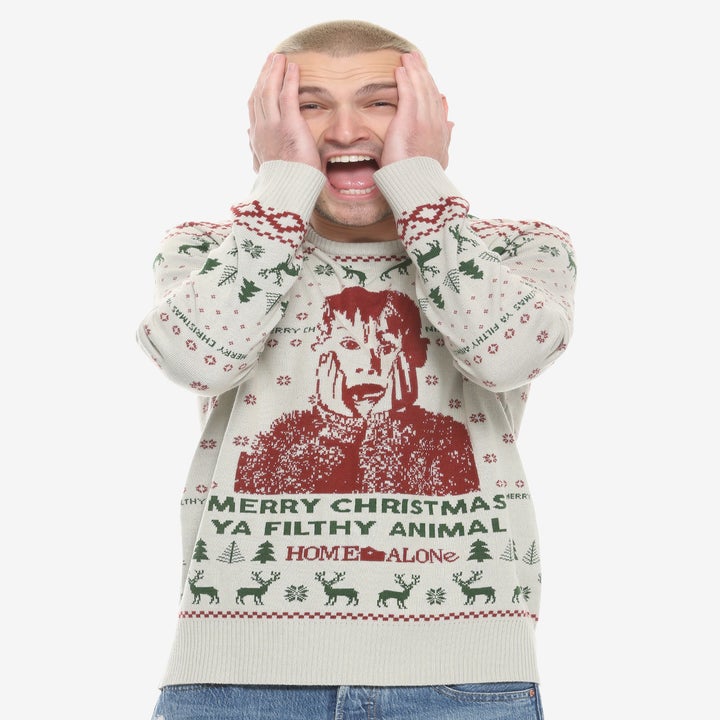 a model in a holiday sweater with kevin from home alone on it and the words "merry christmas ya filthy animal"