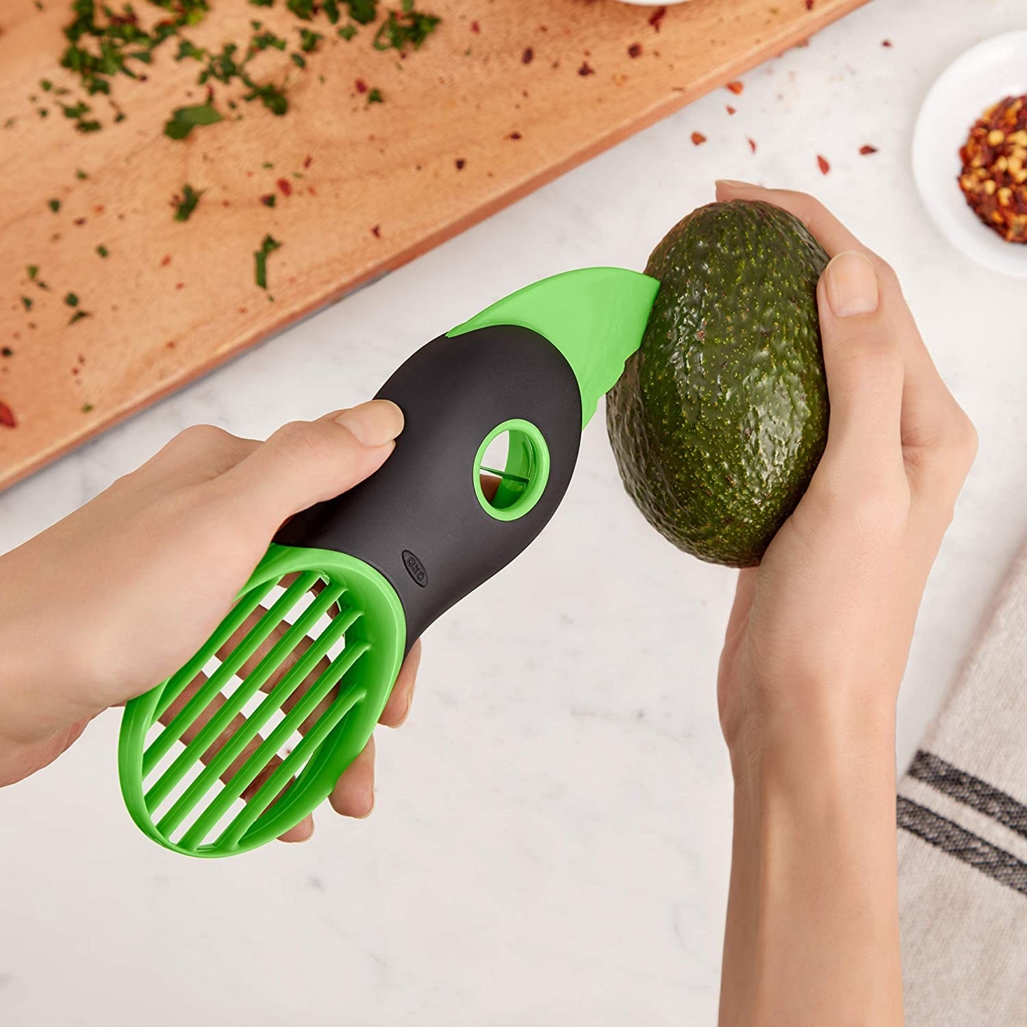 person cutting avocado open with tool