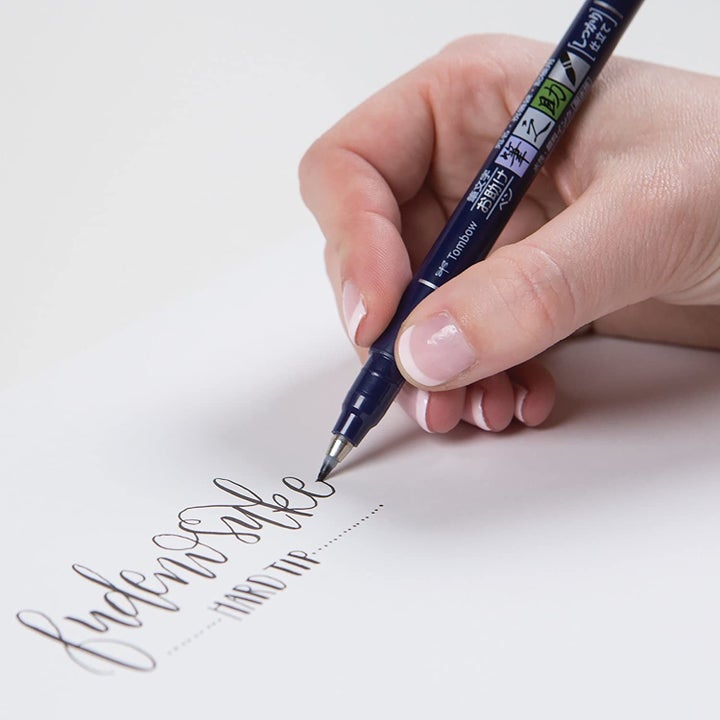 A person writing with a pen