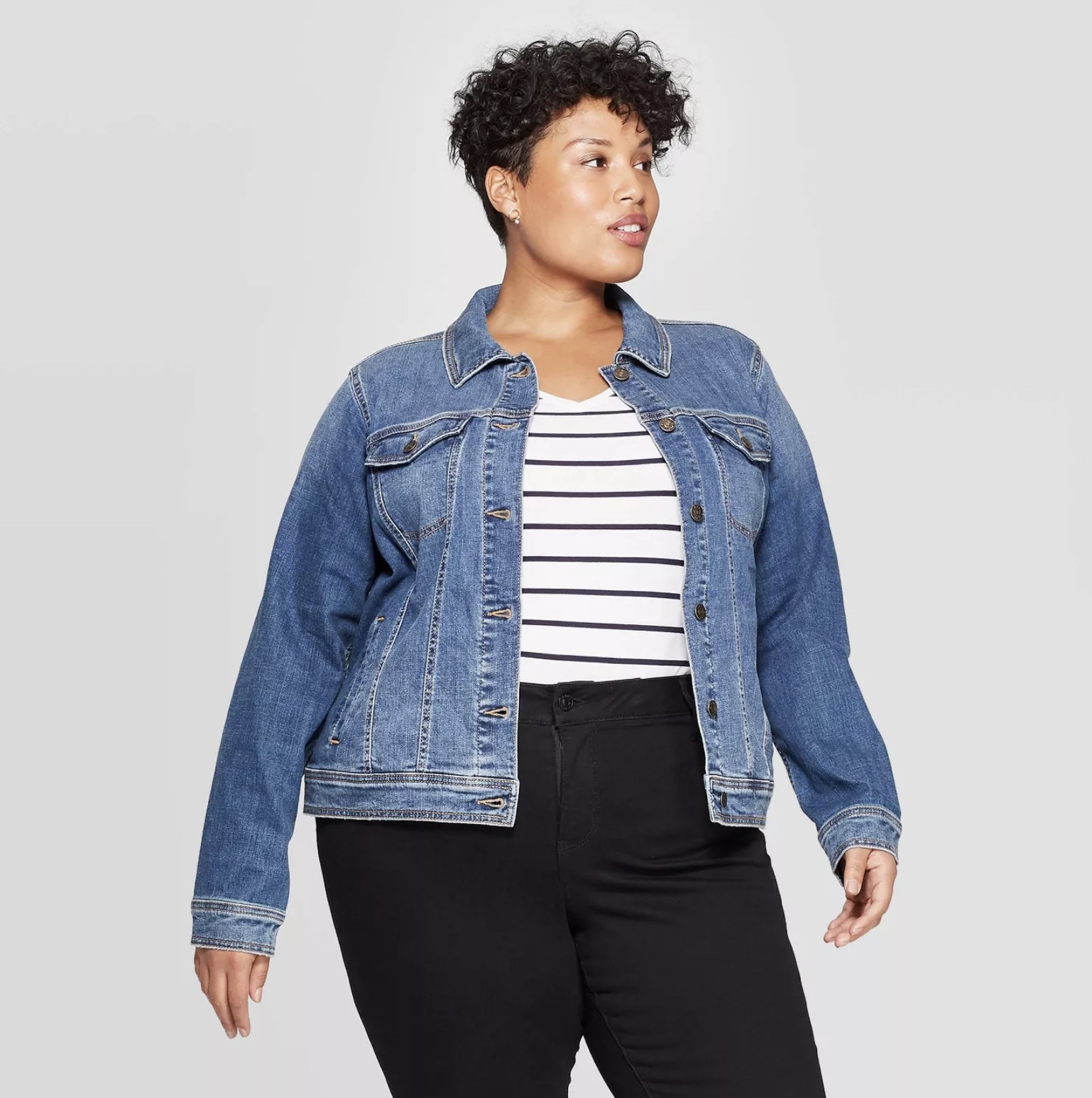 Model is wearing a blue denim jacket, a striped shirt, and black pants