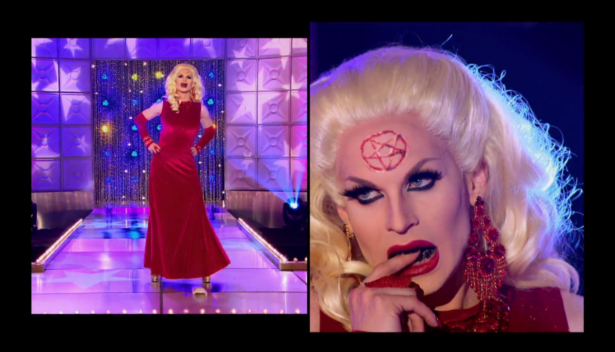 Drag queen Katya wearing a red velvet gown with black teeth and a bloody pentagram on her forehead