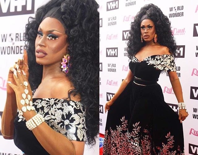 Drag queen Shea Couleé wearing a black gown with silver floral accents and a big curly black wig