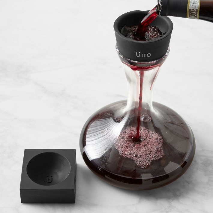 Model pouring red wine through Ullo purifier into decanter