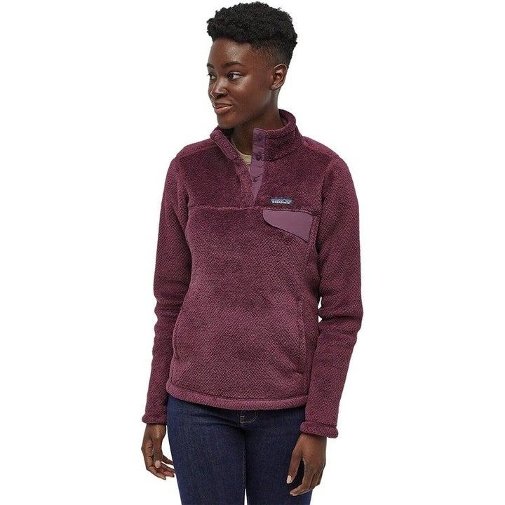 a model in a purple fleece jacket with buttons half way from the top