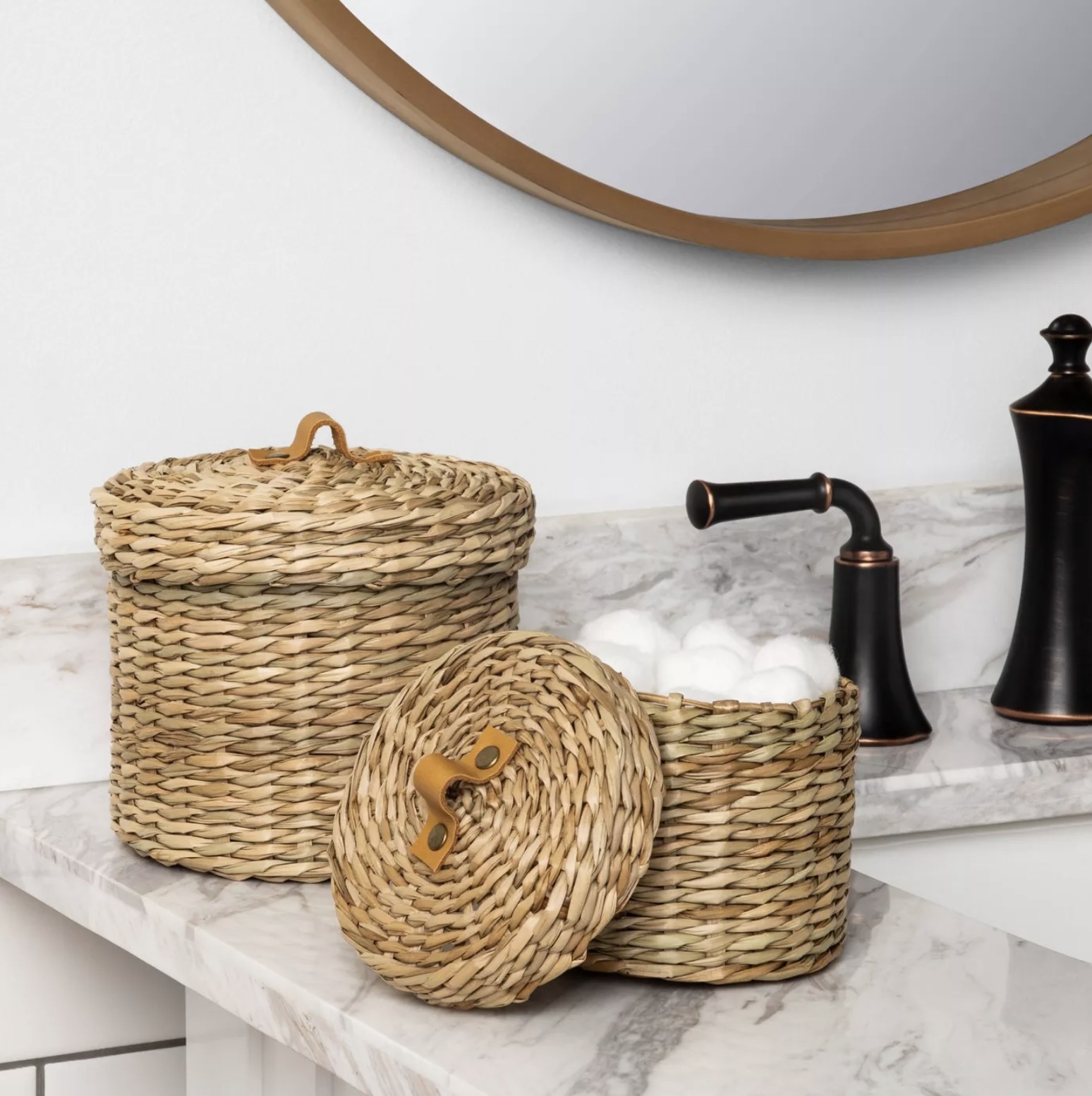 Two woven storage canisters on a bathroom sink