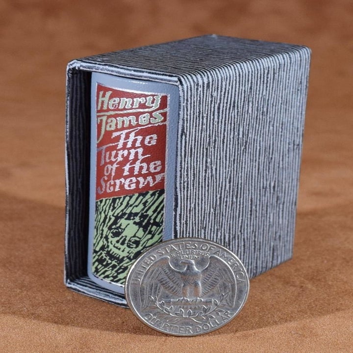 A miniature book that says The Turn of the Screw that's about the size of 3 quarters