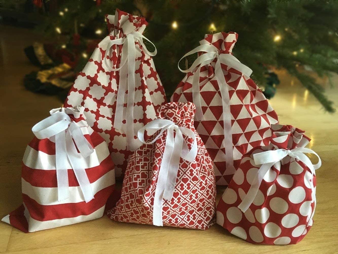 five gift sacks of various red and white patterns