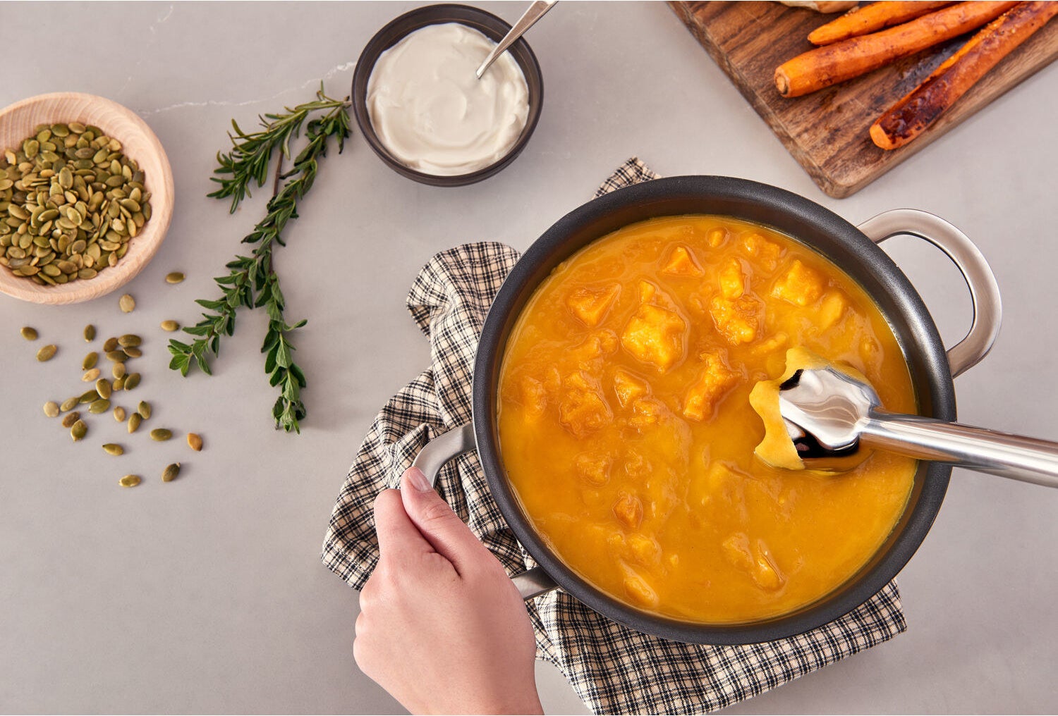 The blender in a pot of orange soup