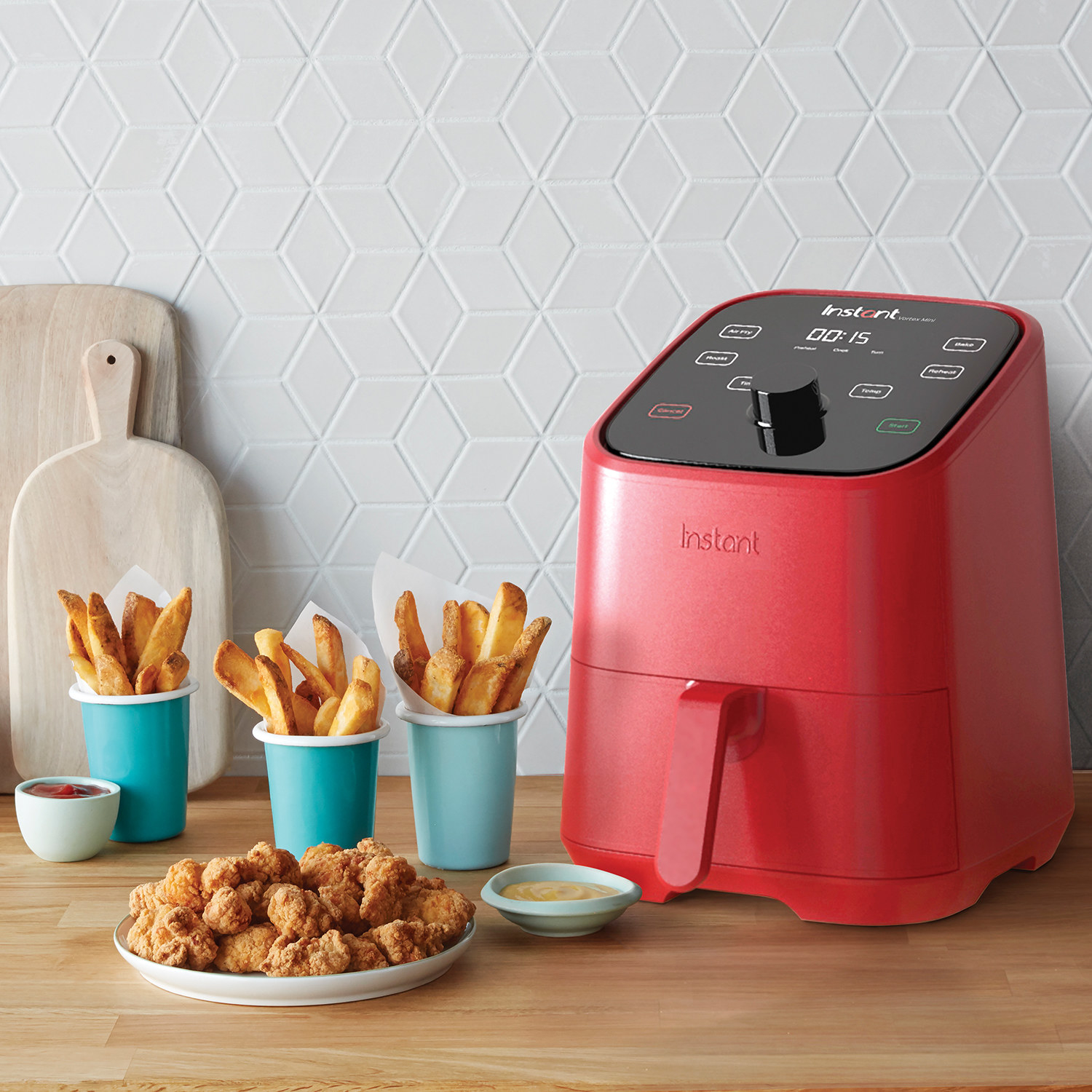 The red air fryer next to fries and chicken nuggets