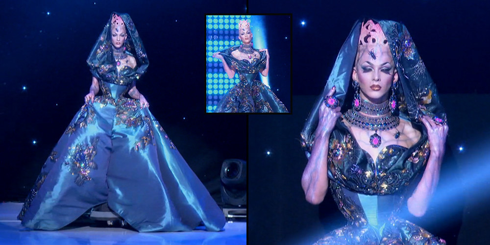 Drag queen Violet Chachki wearing an enormous blue embellished gown with creepy bug accents and a crown that appears to be growing out of her head