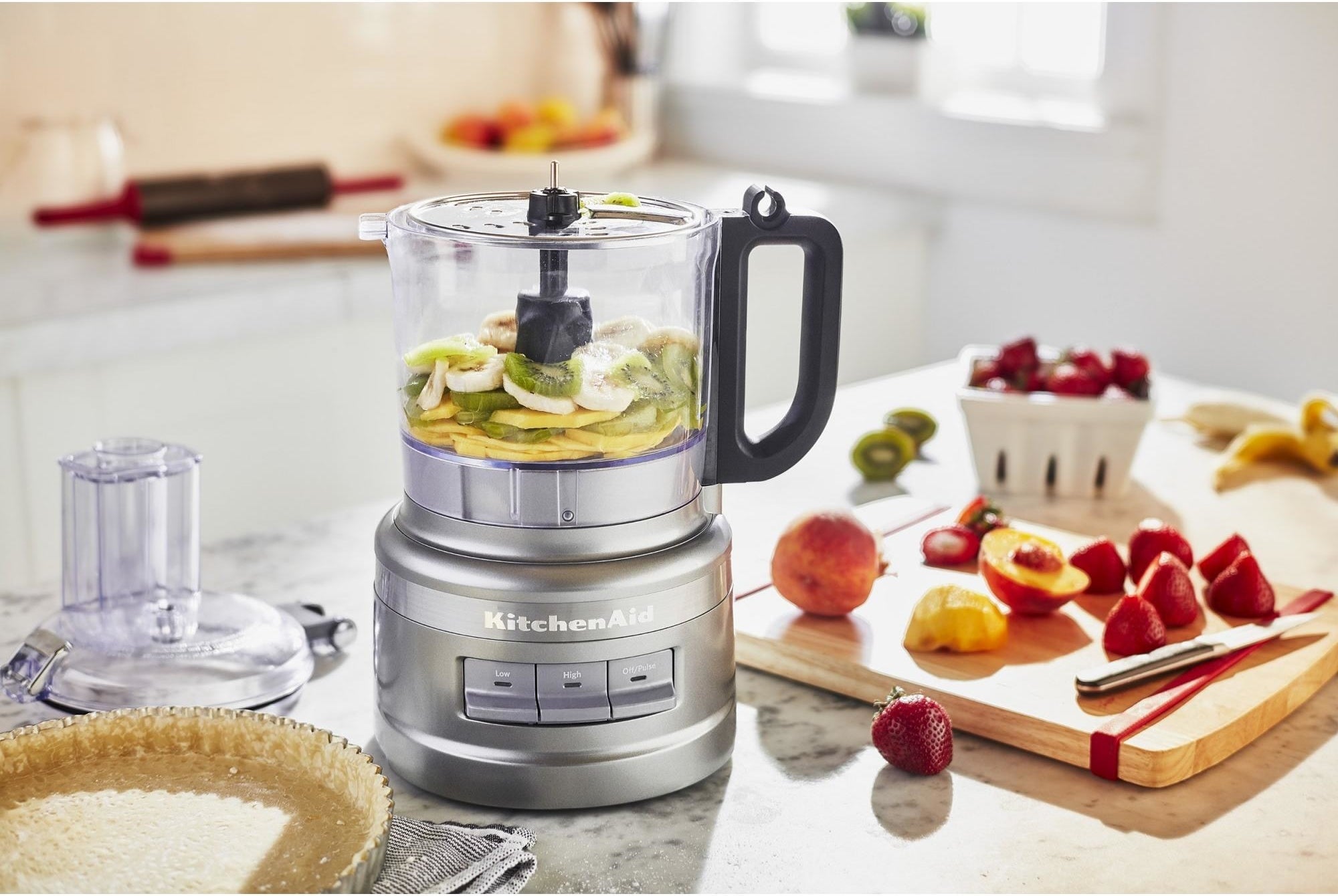 The food processor in a kitchen, full of fruits