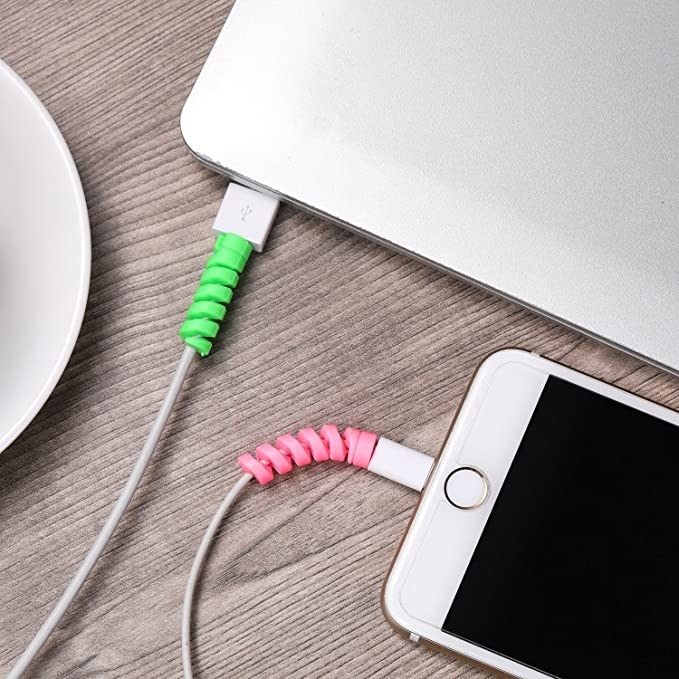 Green and pink cable savers around frayed phone charger wire