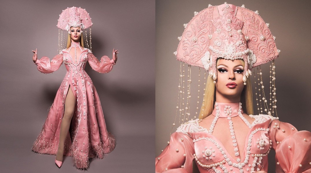 Drag queen Miz Cracker wearing a pink gown and headpiece embellished with pearls and jewels